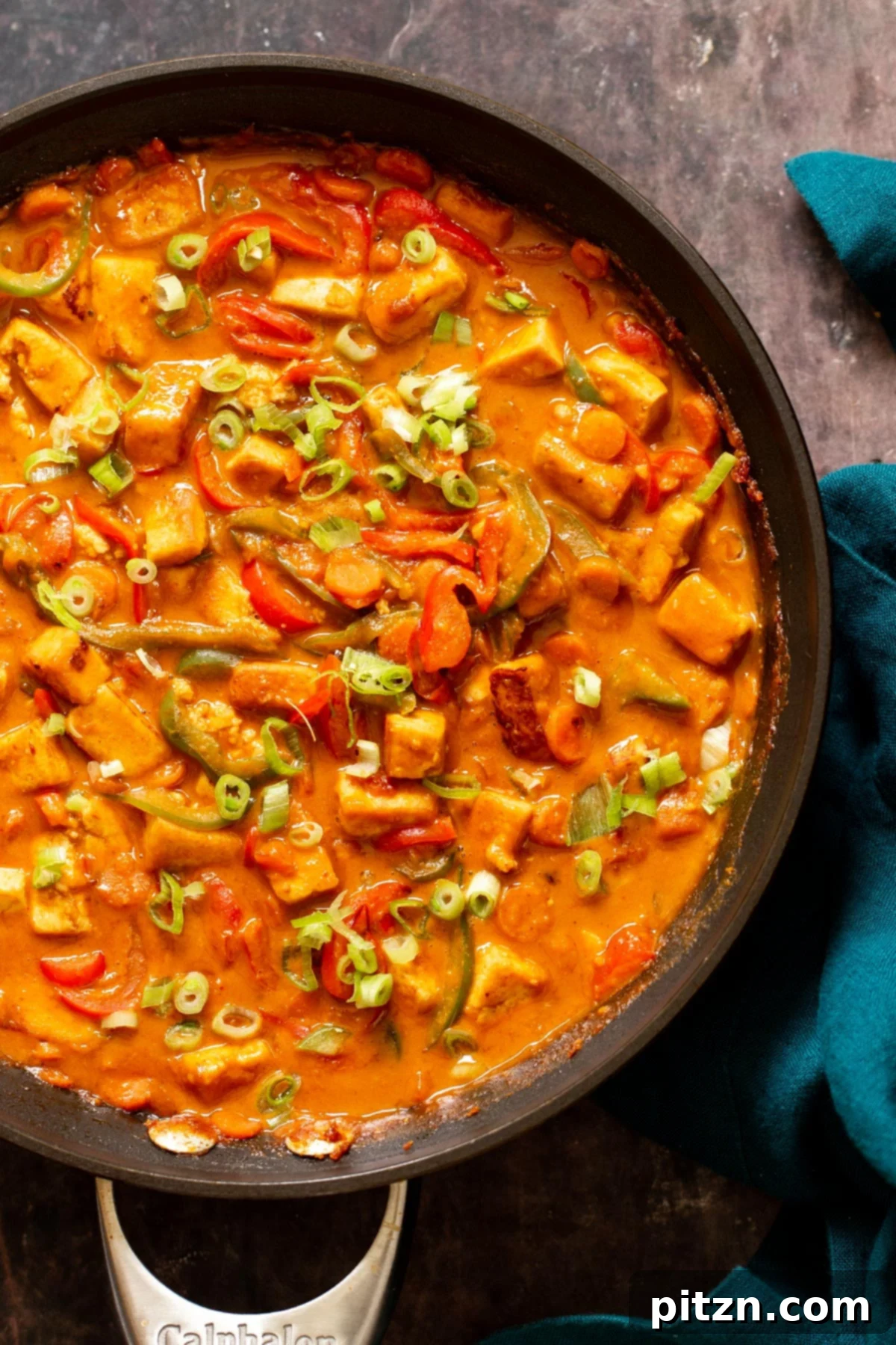 a skillet with veggies and tofu cubes in creamy Korean stir-fry sauce 