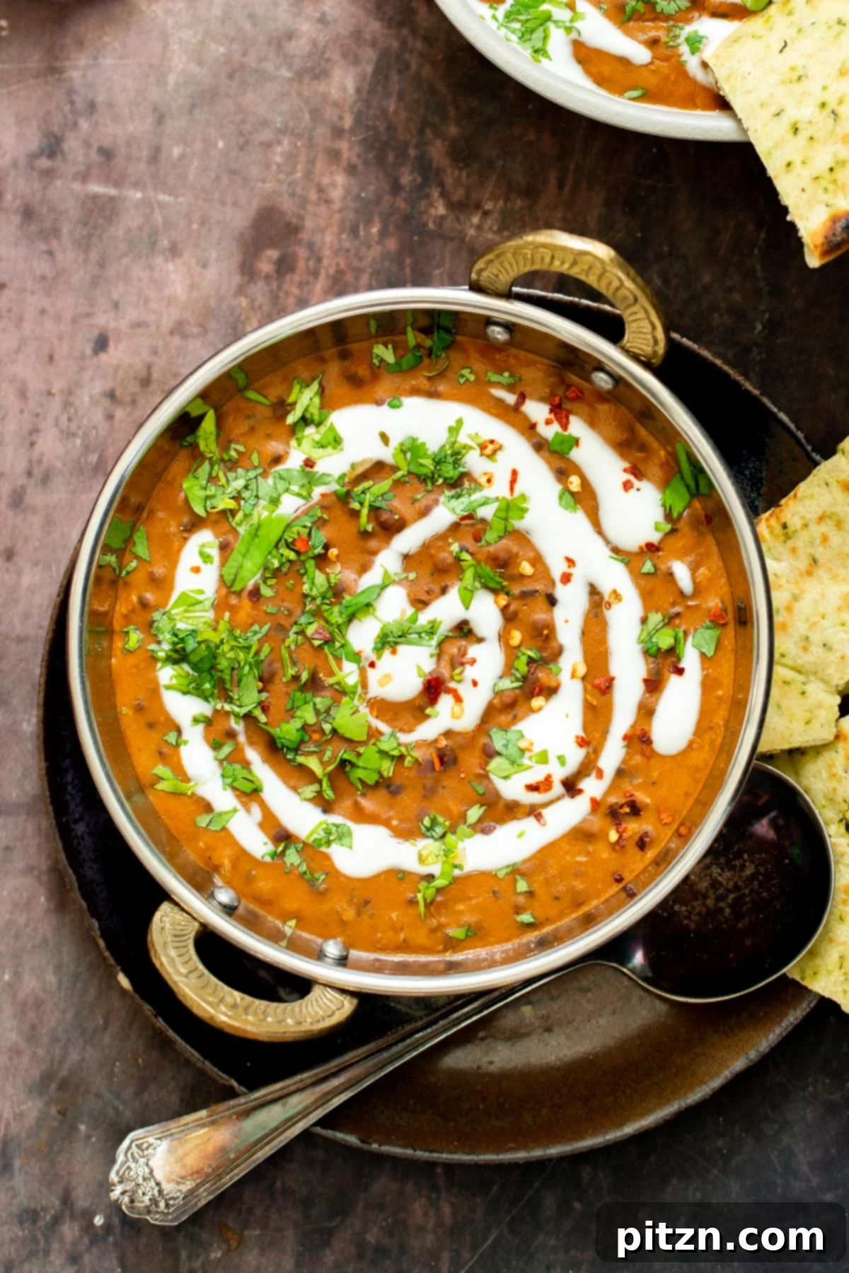Instant Pot Dal Bukhara - Dump and Done Creamy Black Lentil Perfection 3 Dal Bukhara served in an elegant Indian bowl, beautifully drizzled with rich cashew cream and garnished.