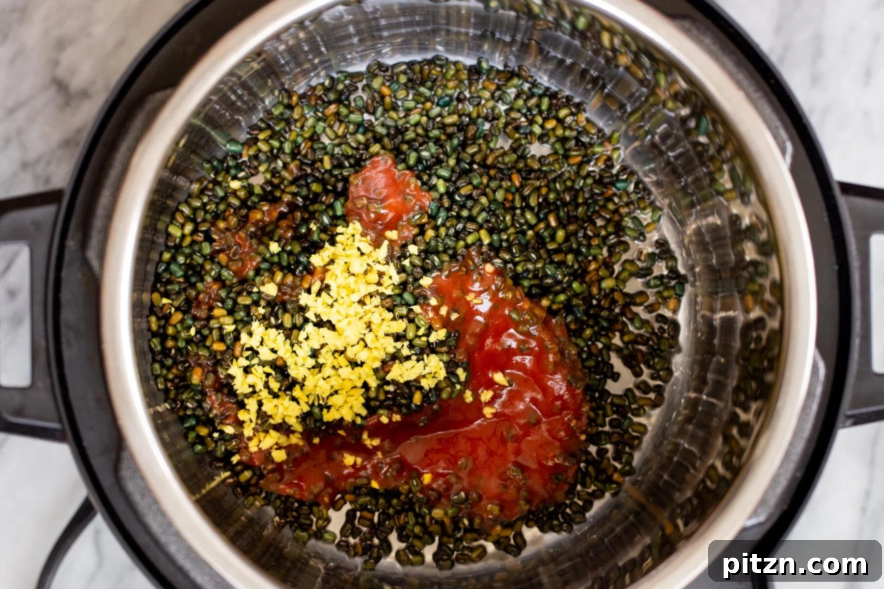 Instant Pot Dal Bukhara - Dump and Done Creamy Black Lentil Perfection 8 Whole black gram lentils, aromatic spices, and fresh ginger being added into the Instant Pot, ready for the cooking process.