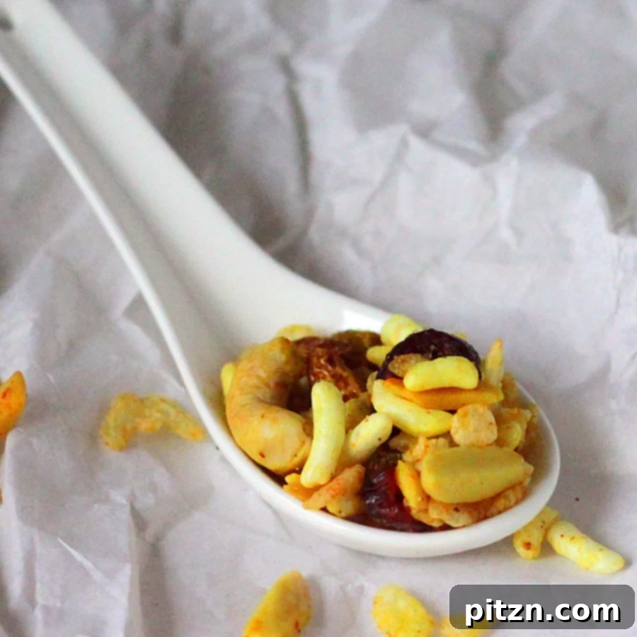 Chivda Savory PlantBased Crunch With Roasted Chickpeas And Fruits 5 A close-up shot of Chivda with visible almond slivers, walnuts, and cashews.