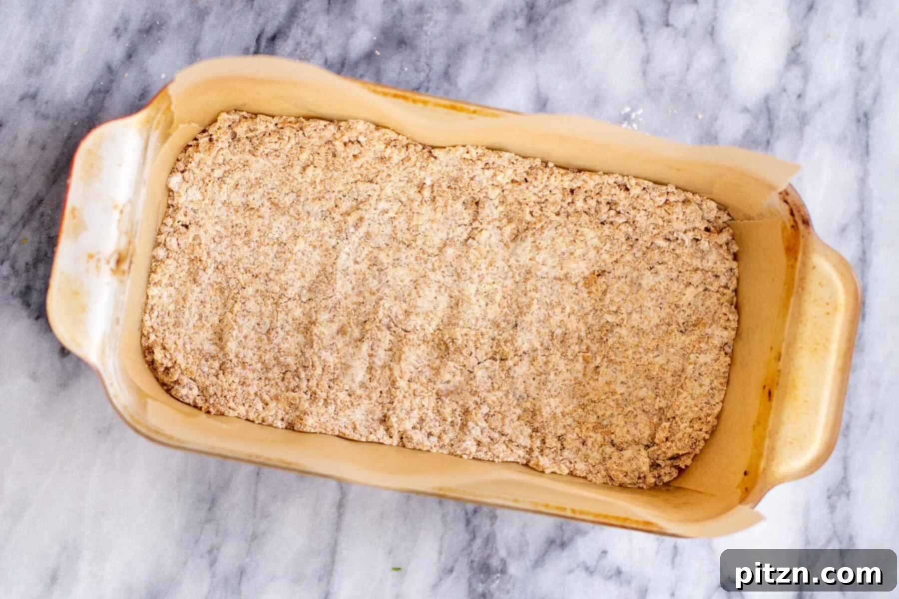 vegan apple pie crust being pressed in a baking dish 