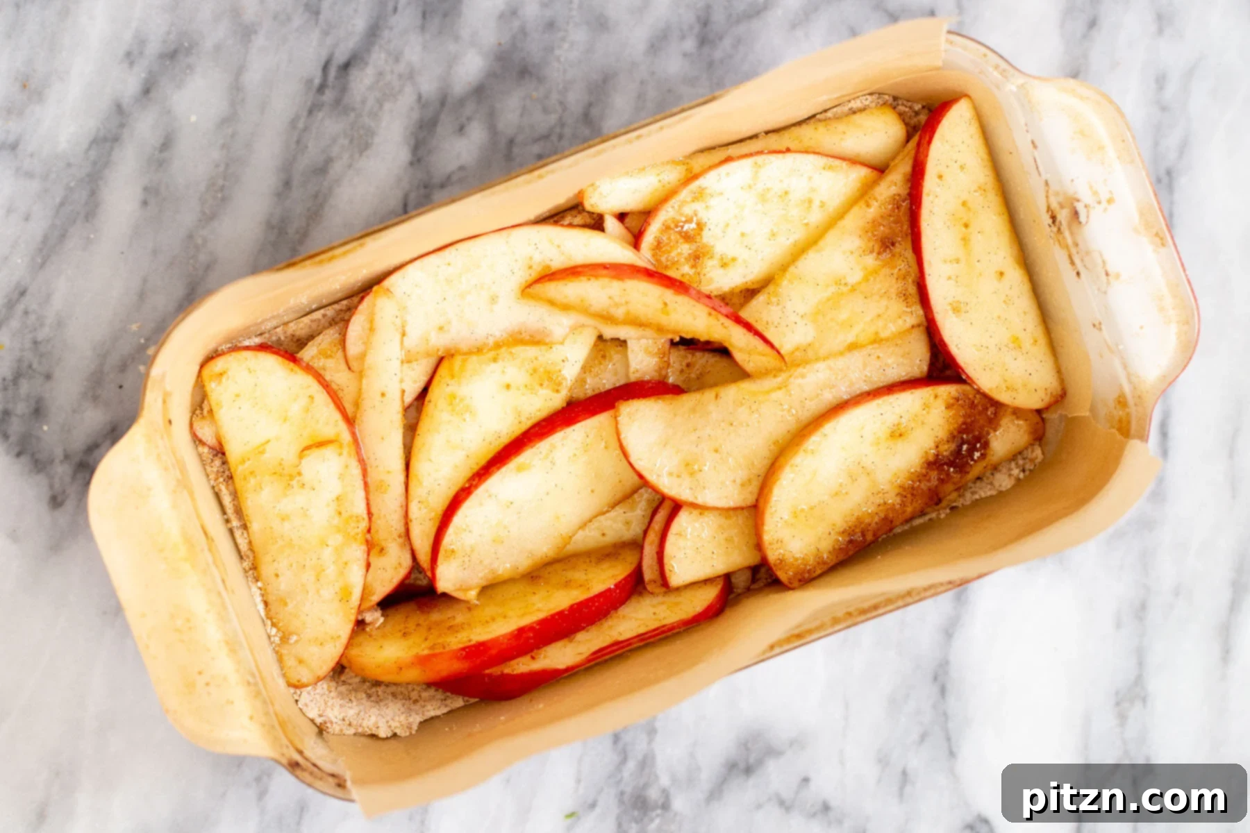 apple slices being added to crust to make vegan apple pie cars 