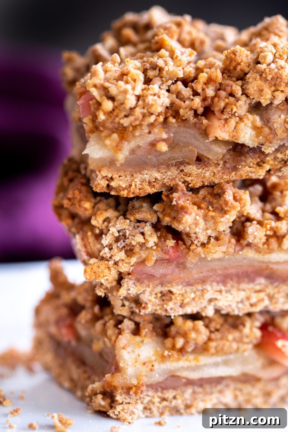 vegan apple pie crumble bars stacked on a plate 