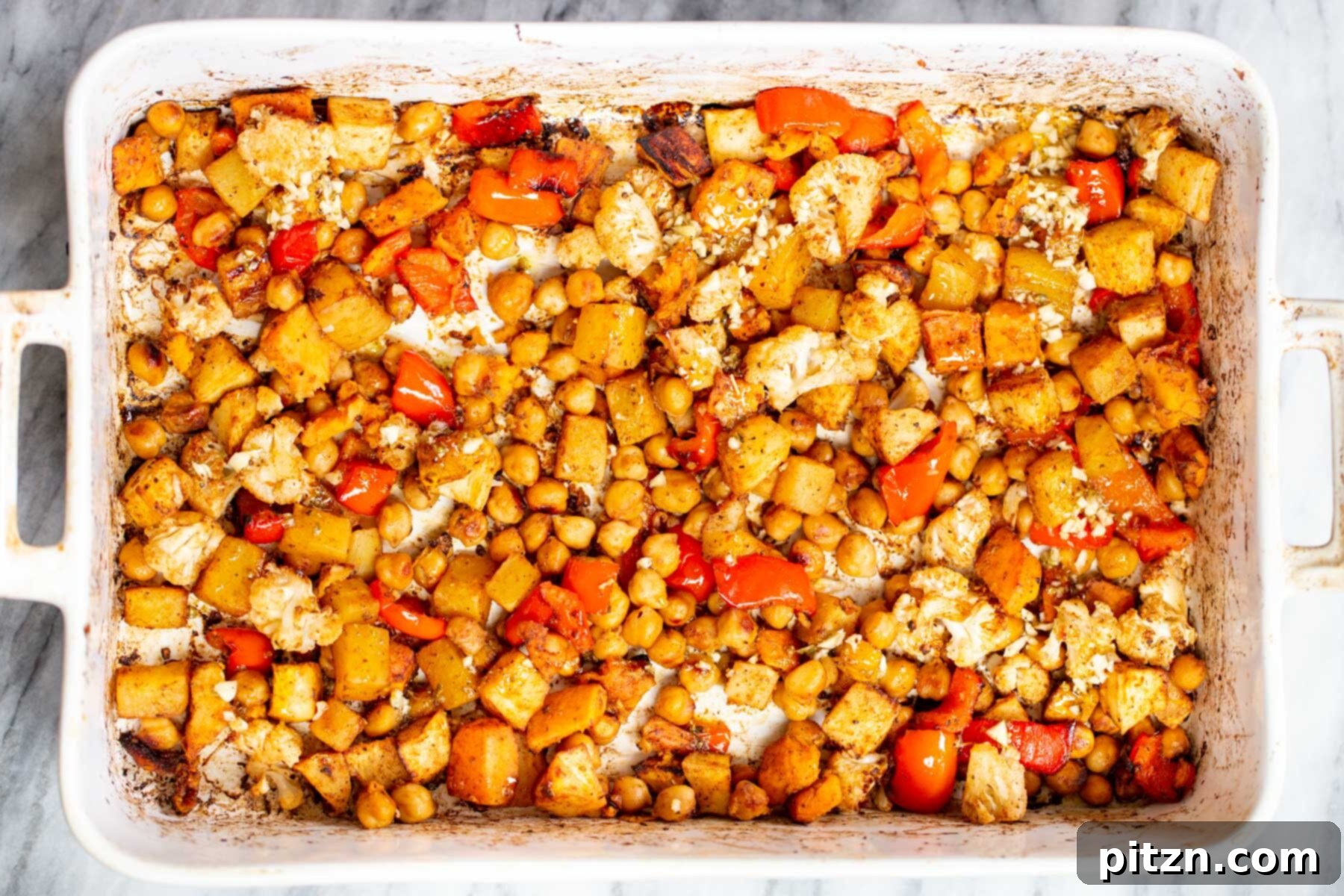 balsamic roasted chickpeas and root vegetables in a white casserole dish