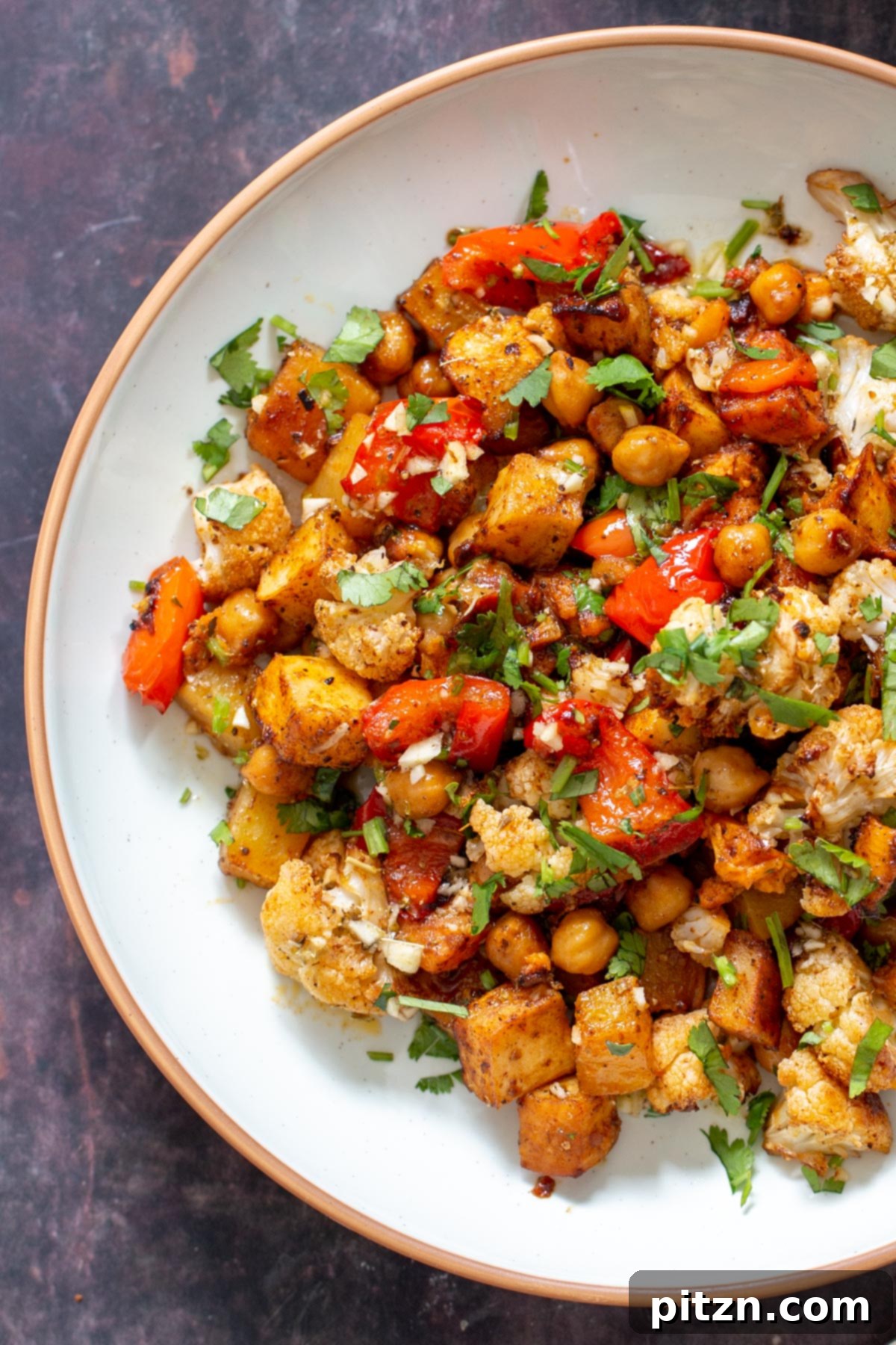vegan roasted root veggies with cauliflower and chickpeas served sprinkled with cilantro