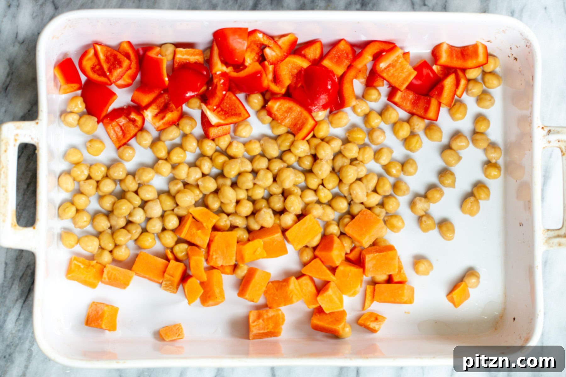 chickpeas bell peppers and squash in a casserole dish