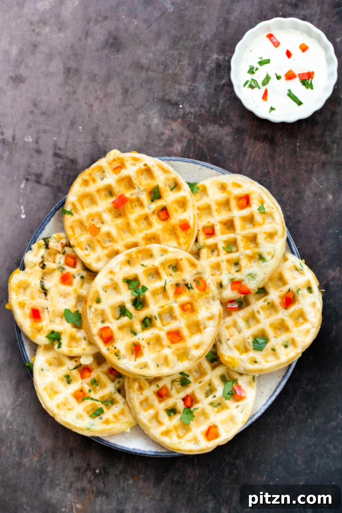 Kickin' Vegan Cheddar Jalapeno Waffles 3 a plate of vegan cheddar jalapeno waffles with a side of sour cream