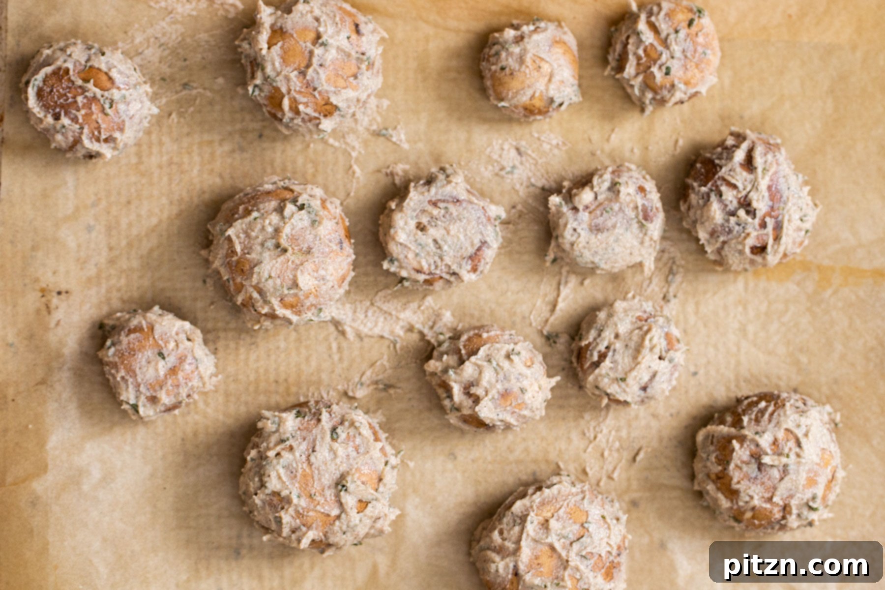 Swedish Plant-Ball Perfection 12 Marinated cremini mushrooms baking in a single layer on a parchment-lined sheet pan.