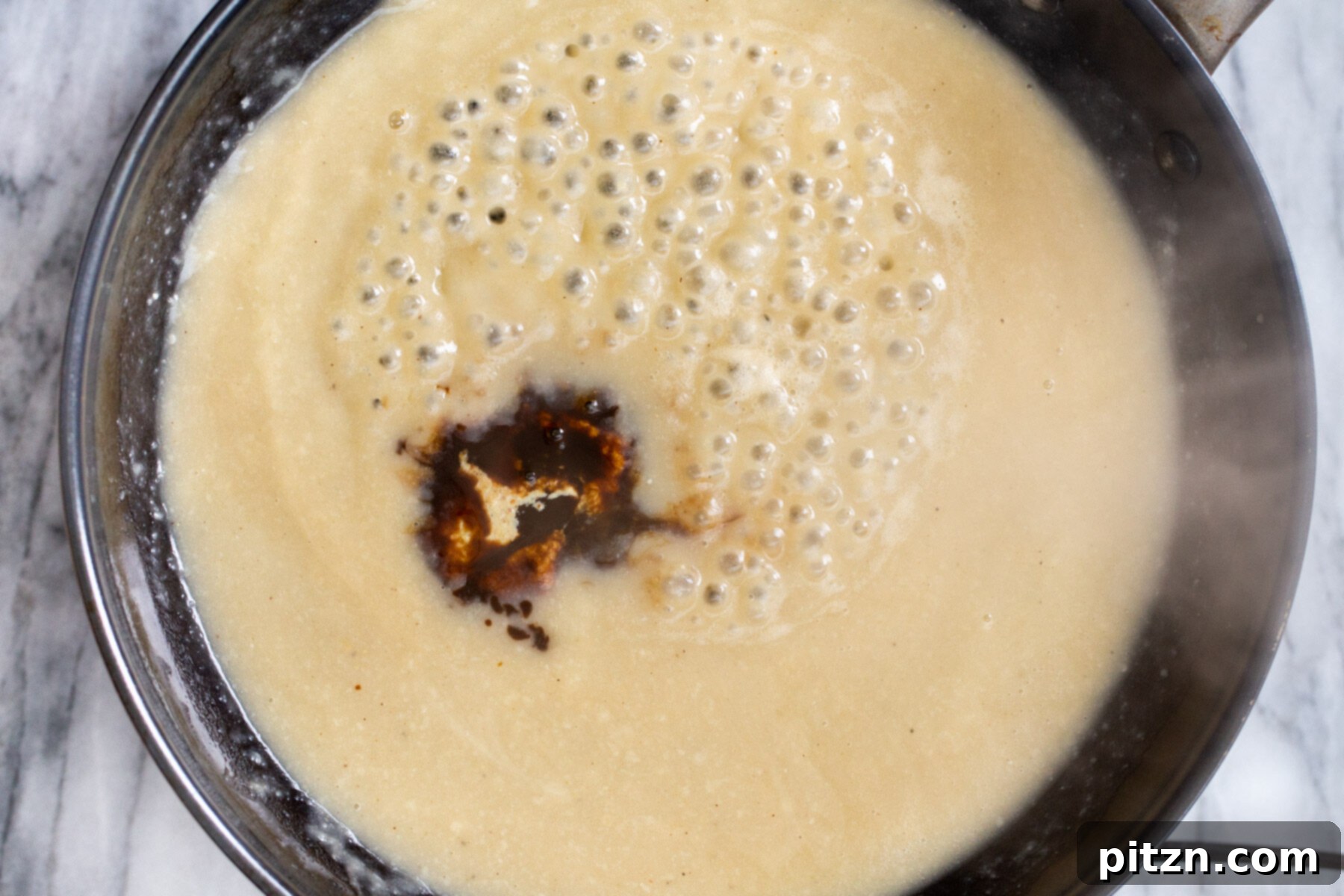 Swedish Plant-Ball Perfection 15 Vegan Worcestershire sauce being poured into the bubbling vegan roux in a skillet.