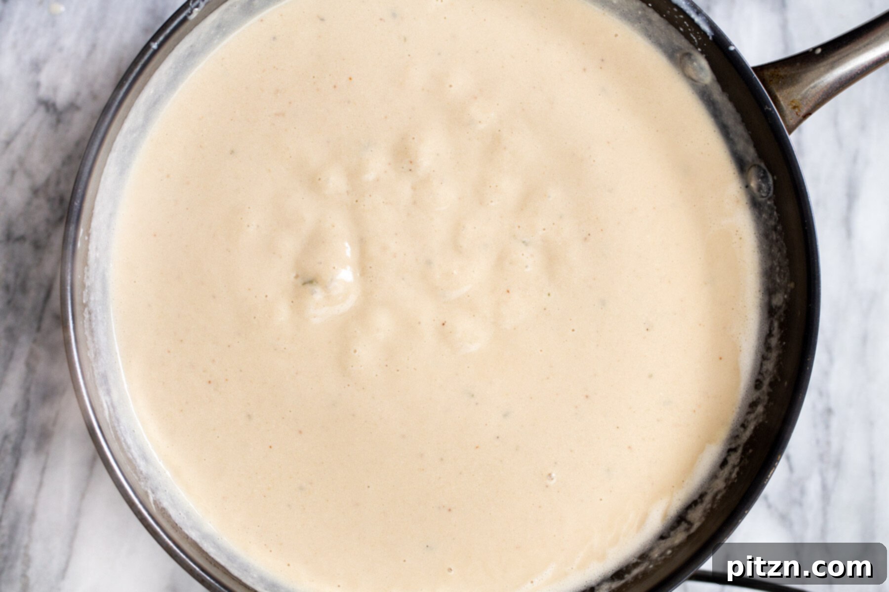 Swedish Plant-Ball Perfection 18 Smooth and creamy vegan mushroom gravy simmering gently in a saucepan.