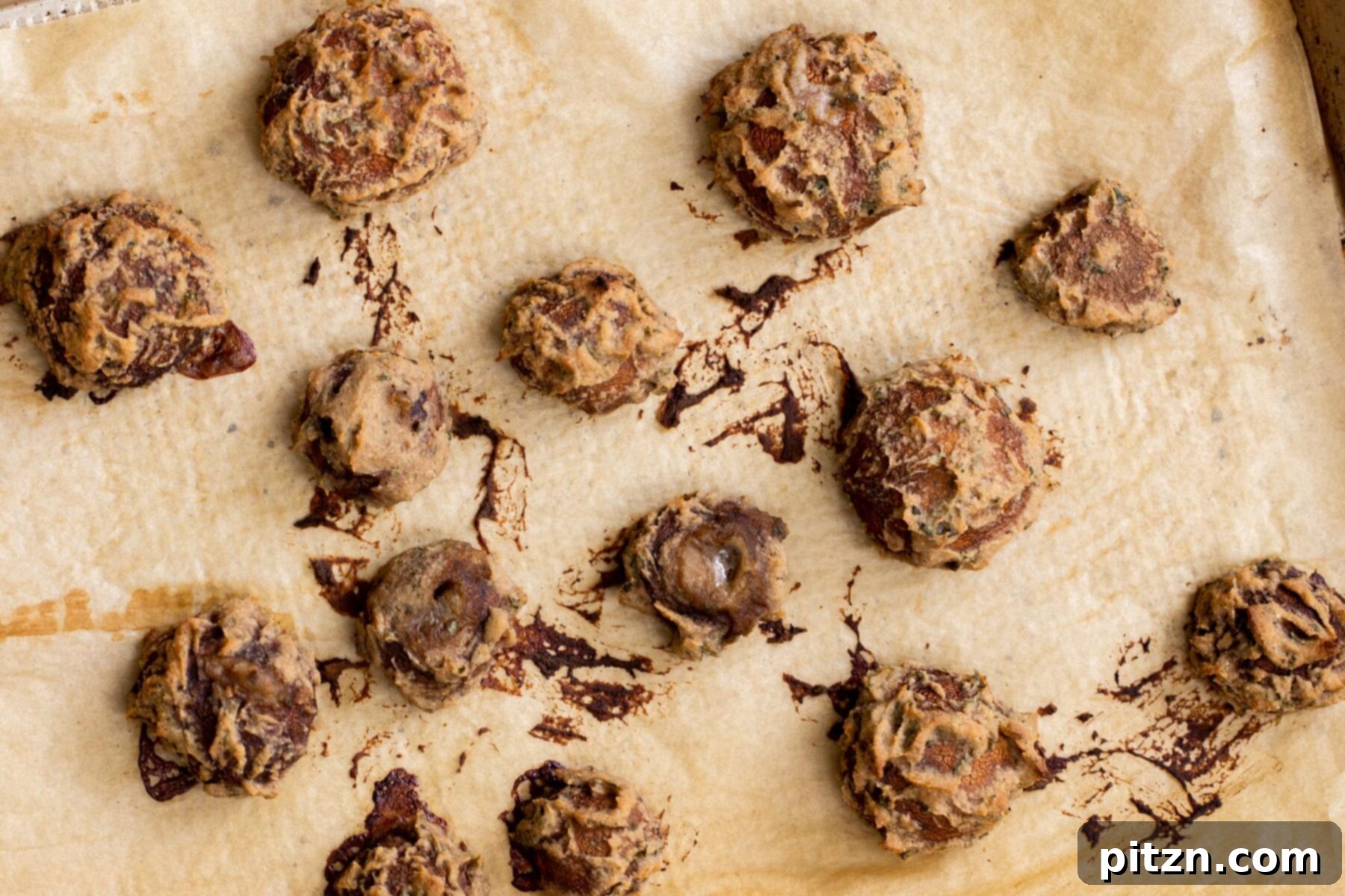 Swedish Plant-Ball Perfection 19 Golden-brown baked mushroom balls cooling on a parchment-lined sheet pan after cooking.