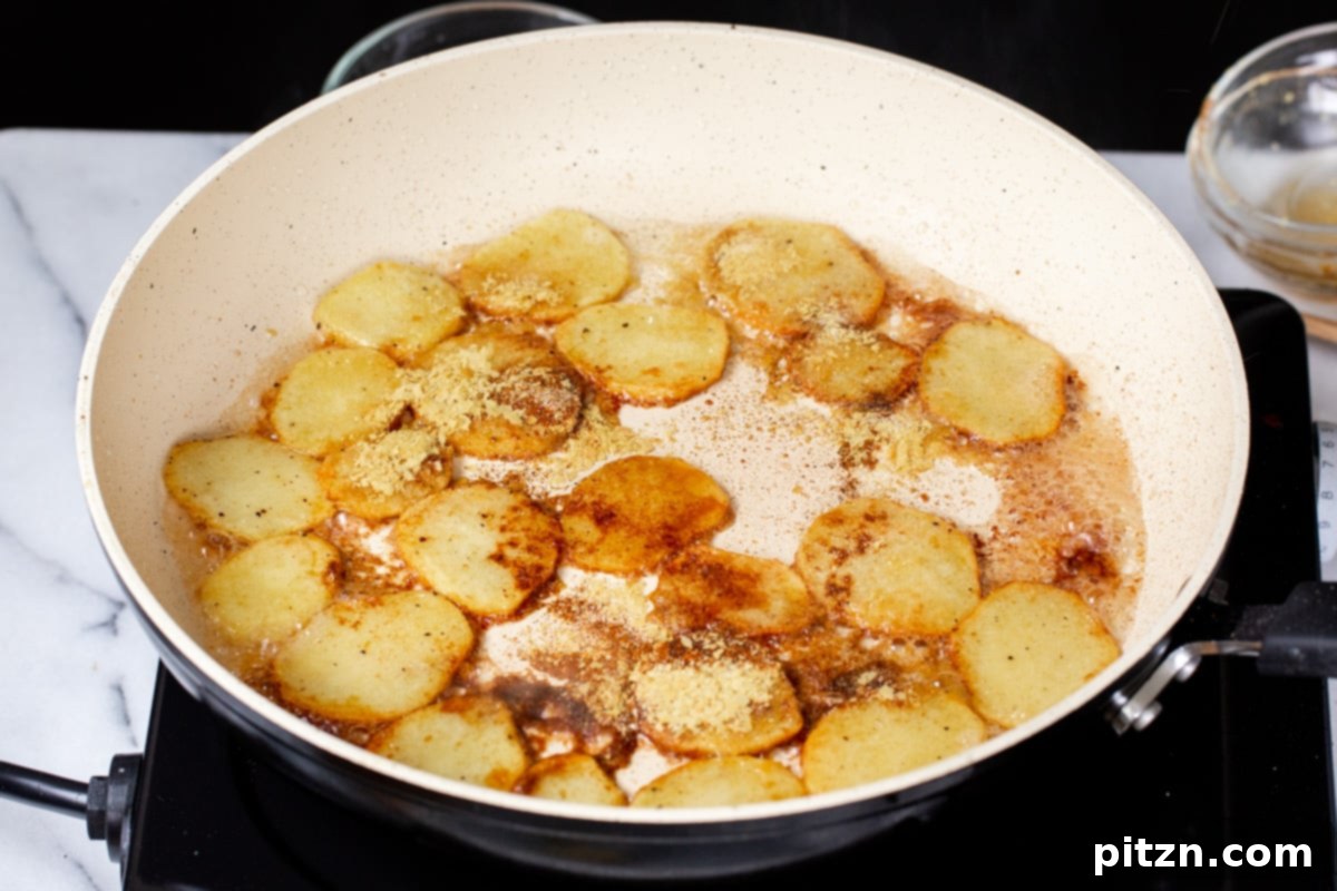 Smoky Tofu and Potato Sunrise Quesadillas 12 Various spices being added to golden-fried sliced potatoes in a white pan, for the smoky marinade.