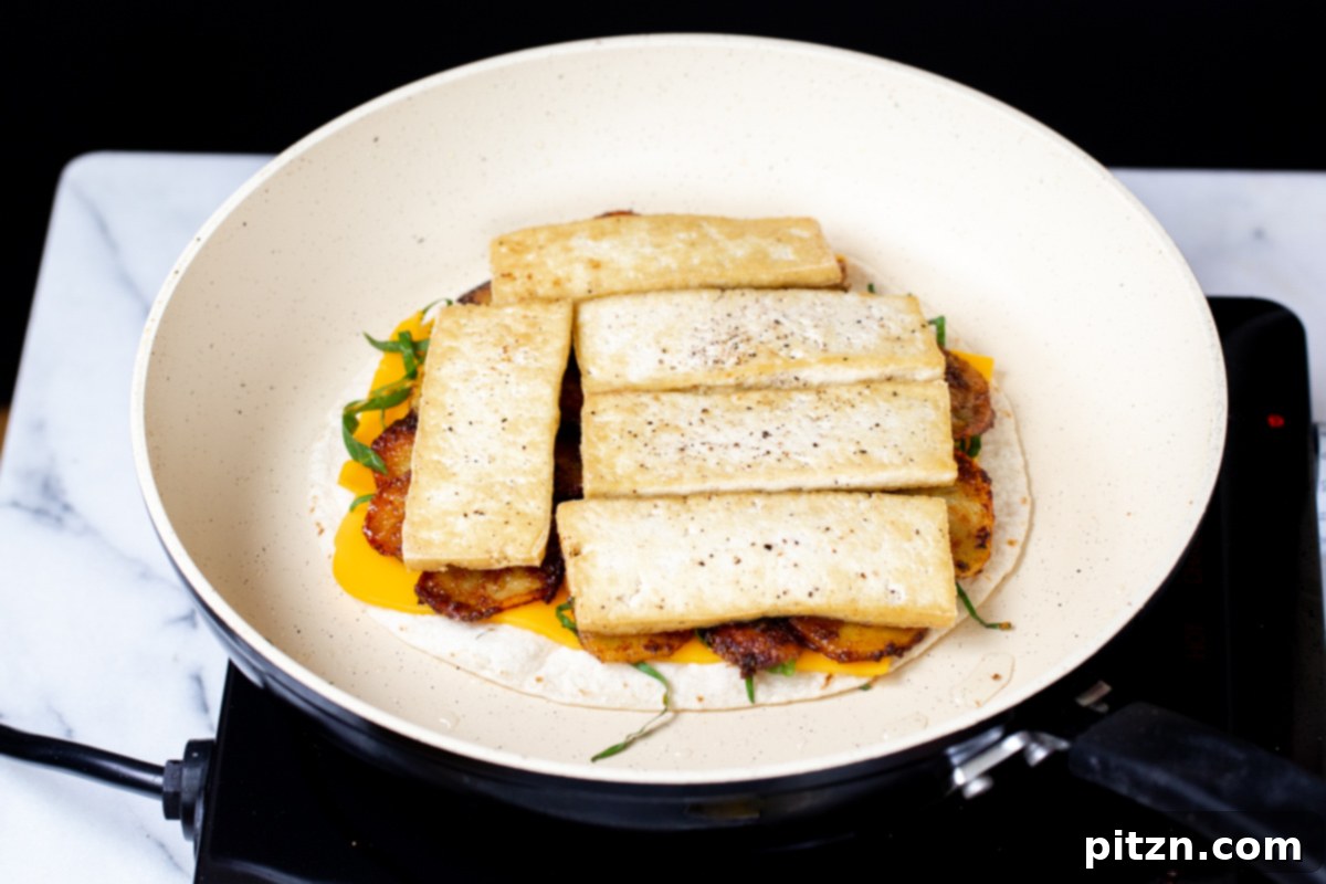 Smoky Tofu and Potato Sunrise Quesadillas 16 A vegan quesadilla being layered with delicious cheese and golden tofu slices, building the perfect bite.