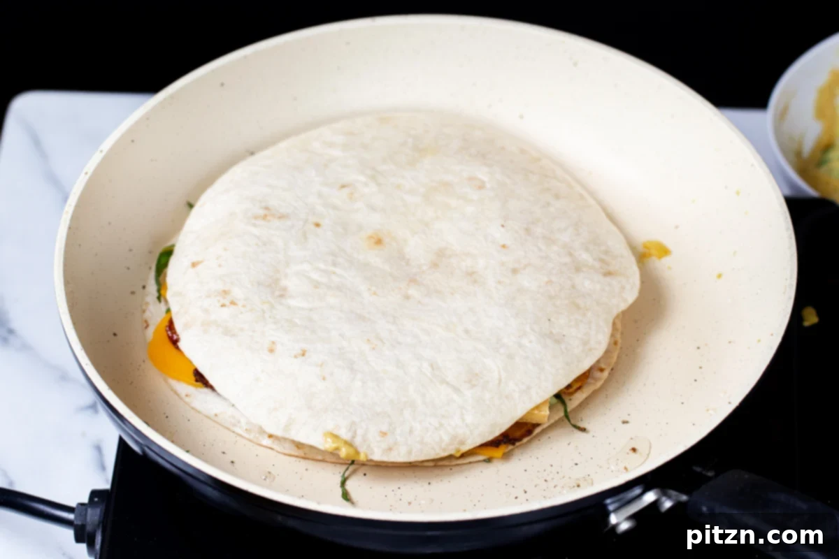 Smoky Tofu and Potato Sunrise Quesadillas 17 A prepared vegan quesadilla cooking to perfection in a white pan, turning golden brown.