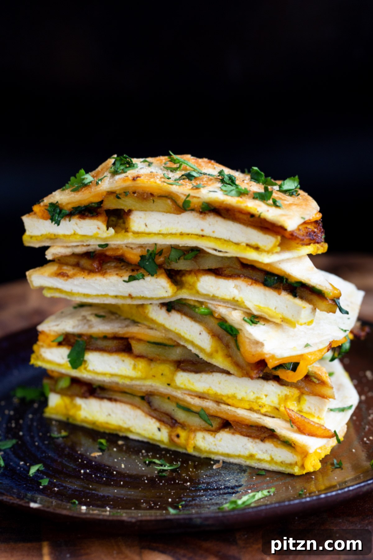 Smoky Tofu and Potato Sunrise Quesadillas 20 A close-up of stacked vegan breakfast quesadilla wedges, highlighting the delicious fillings of hummus, tofu, and potatoes.