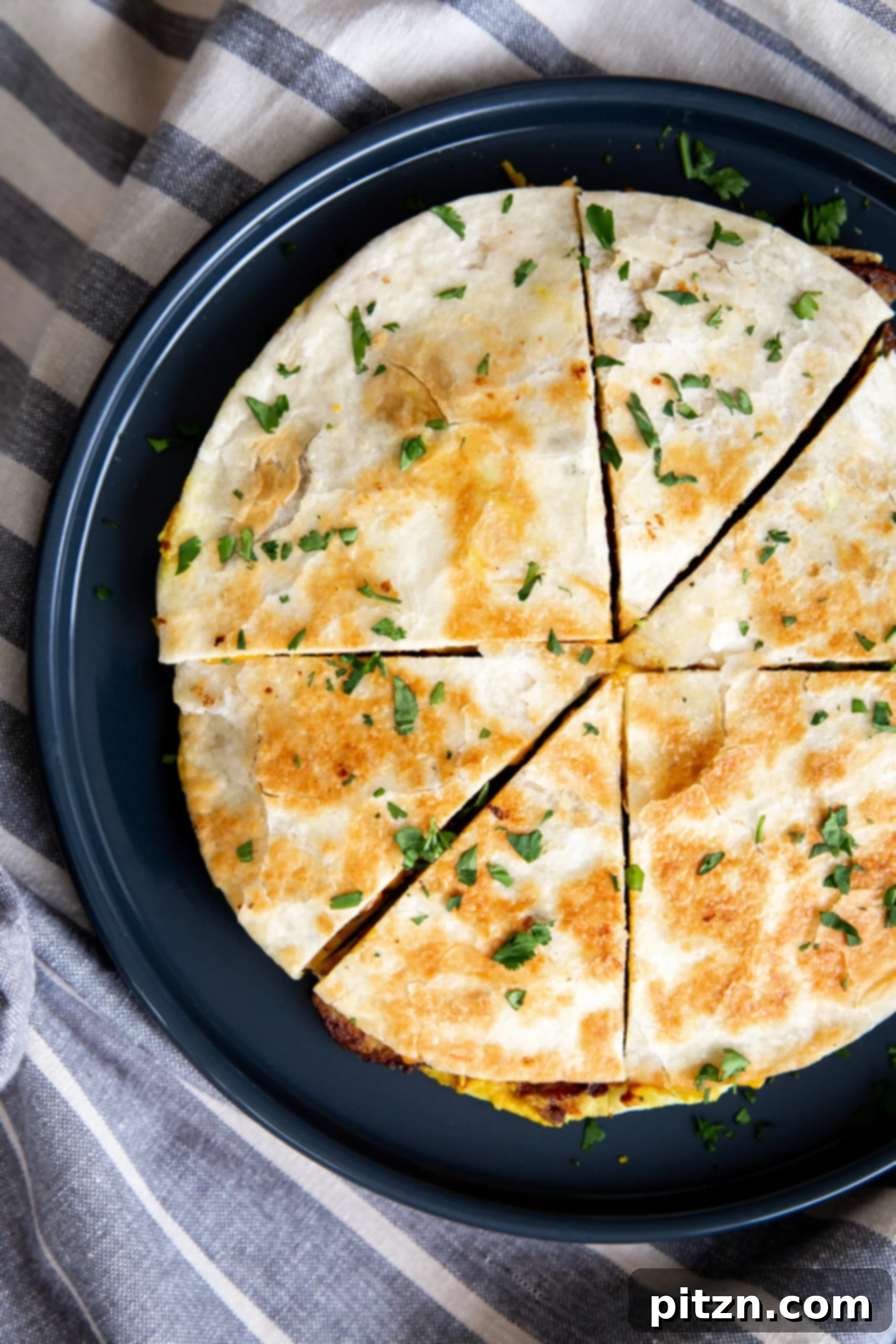 Smoky Tofu and Potato Sunrise Quesadillas 4 Overhead shot of vegan breakfast quesadilla cut into wedges, lightly sprinkled with fresh parsley.