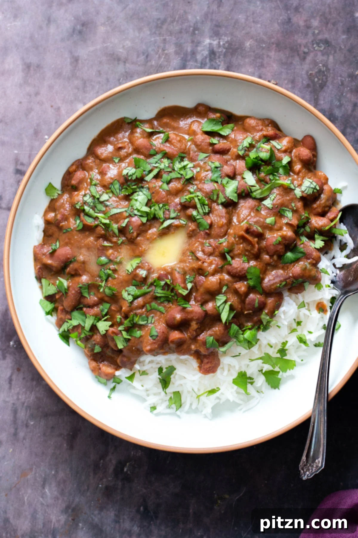Instant Pot Dhaba Rajma: Authentic & Easy Kidney Bean Curry 2 overhead shot of a plate of red kidney bean curry served with rice, garnished with fresh cilantro