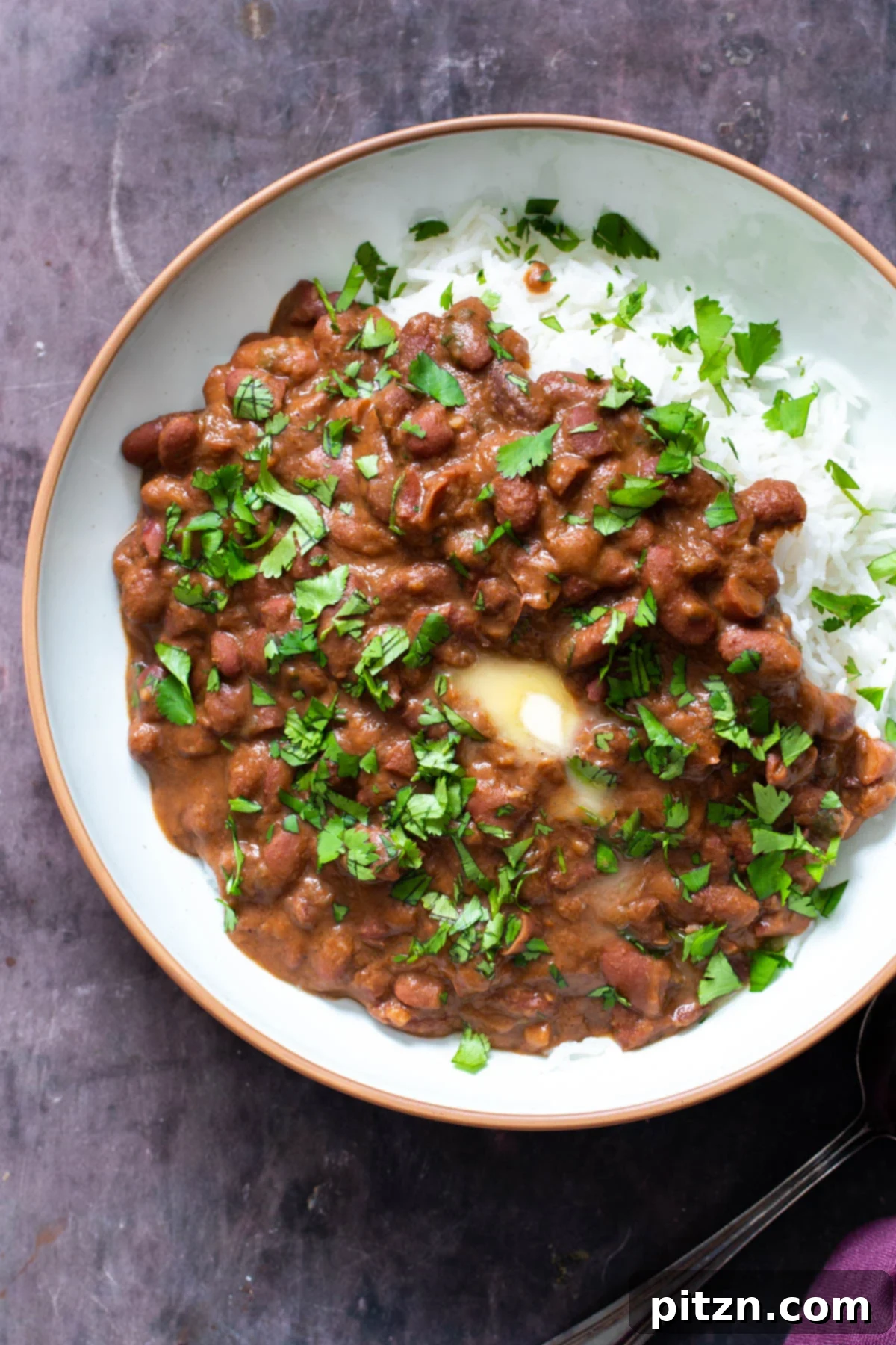 Instant Pot Dhaba Rajma: Authentic & Easy Kidney Bean Curry 5 a serving of Indian Dhaba Wale Rajma Curry presented with a side of steamed rice and topped with a dollop of vegan butter