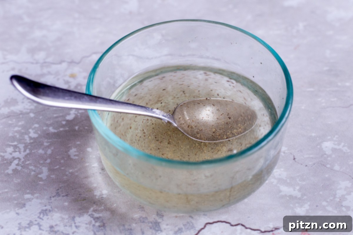 Clear pickling brine mixture in a small glass bowl, ready for the sliced onions