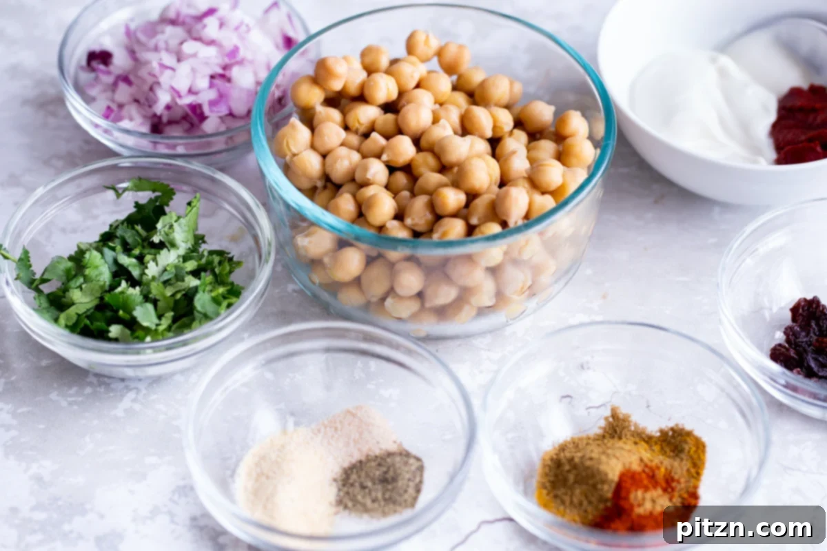 Various ingredients for making vegan egg salad, including chickpeas, spices, herbs, and non-dairy yogurt, neatly arranged