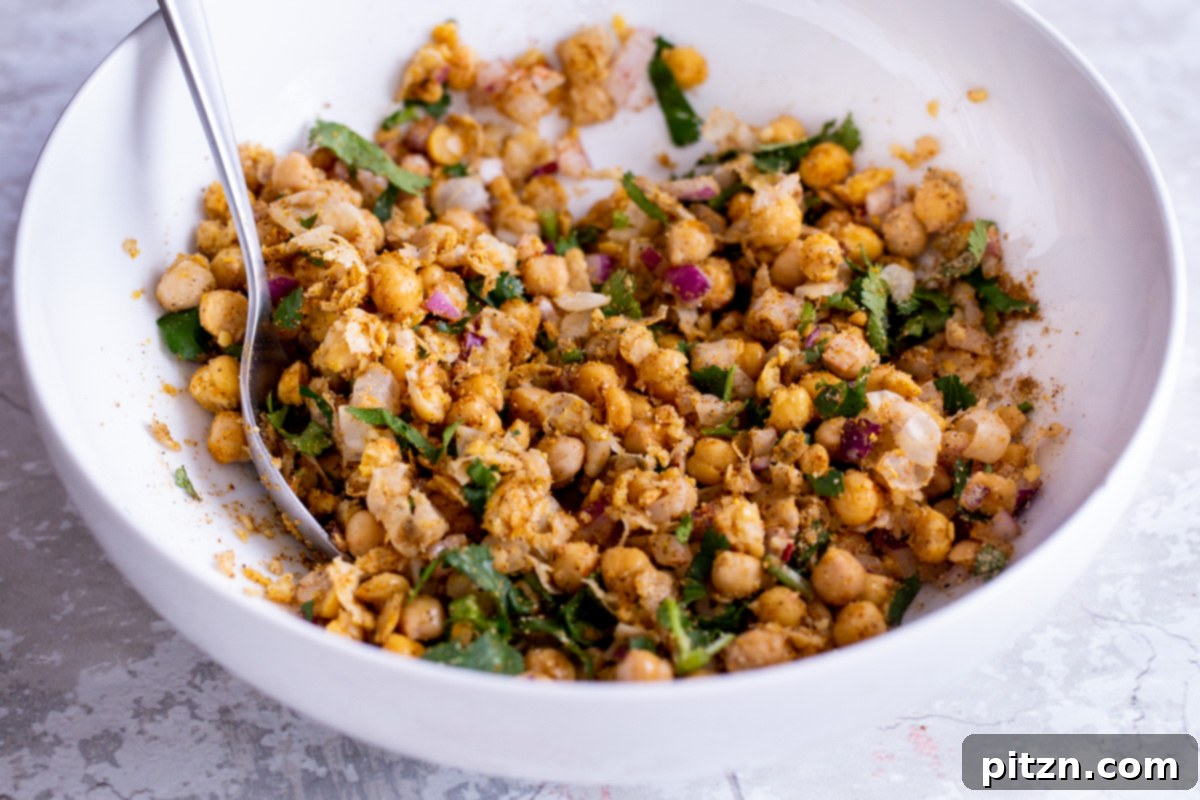 Creamy vegan curried chickpea salad mixture resting in a white bowl, showing its rich texture