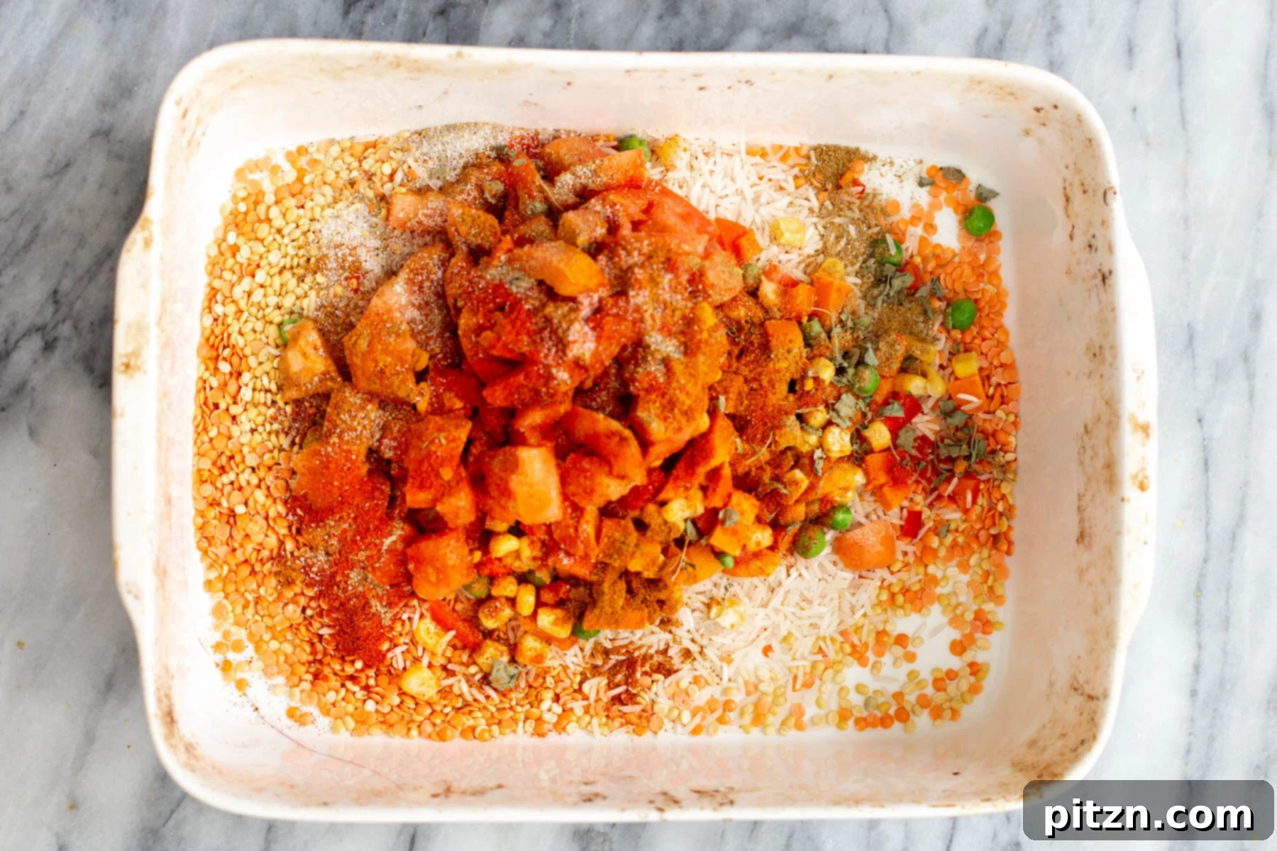 Spiced Kitchari Comfort Bake 10 Aromatic spices being sprinkled over rice and lentils in a casserole dish, infusing the Kitchari casserole with rich Indian flavors before baking.