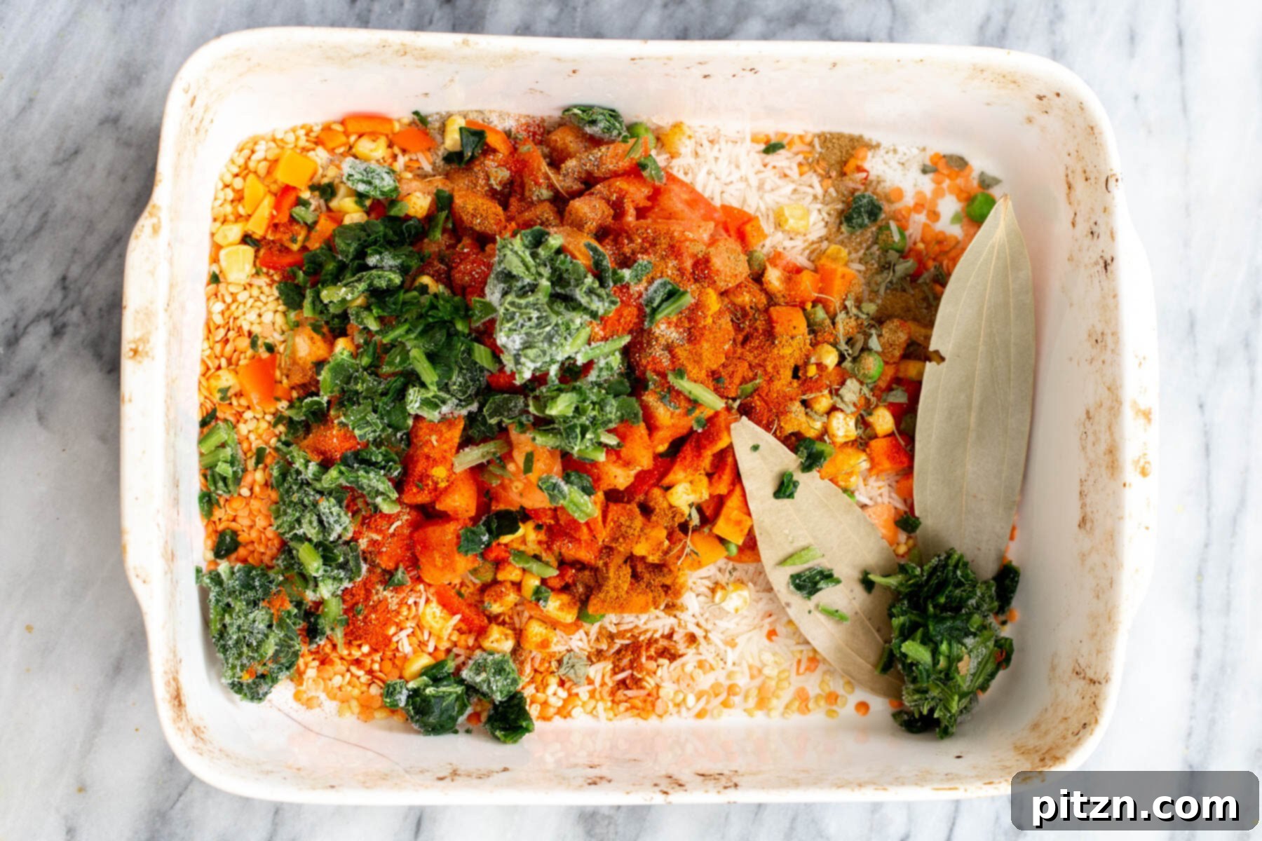 Spiced Kitchari Comfort Bake 11 A variety of colorful veggies being incorporated into a casserole dish with rice and lentils, showcasing the vibrant and wholesome ingredients that make up the Kitchari casserole.
