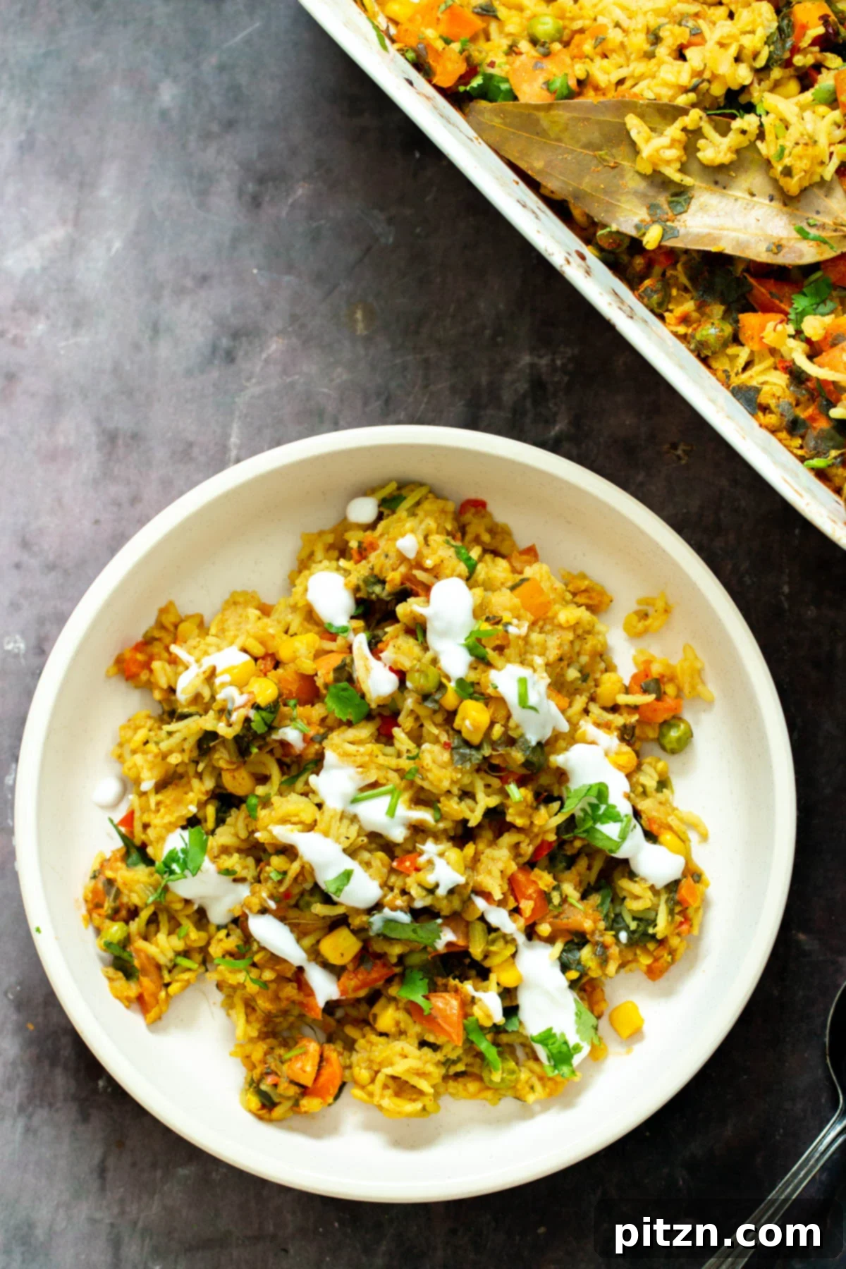 Spiced Kitchari Comfort Bake 15 A delicious plate of vegan lentil rice casserole, elegantly drizzled with creamy plant-based yogurt and garnished with fresh herbs, ready to be savored as a wholesome and fulfilling meal.