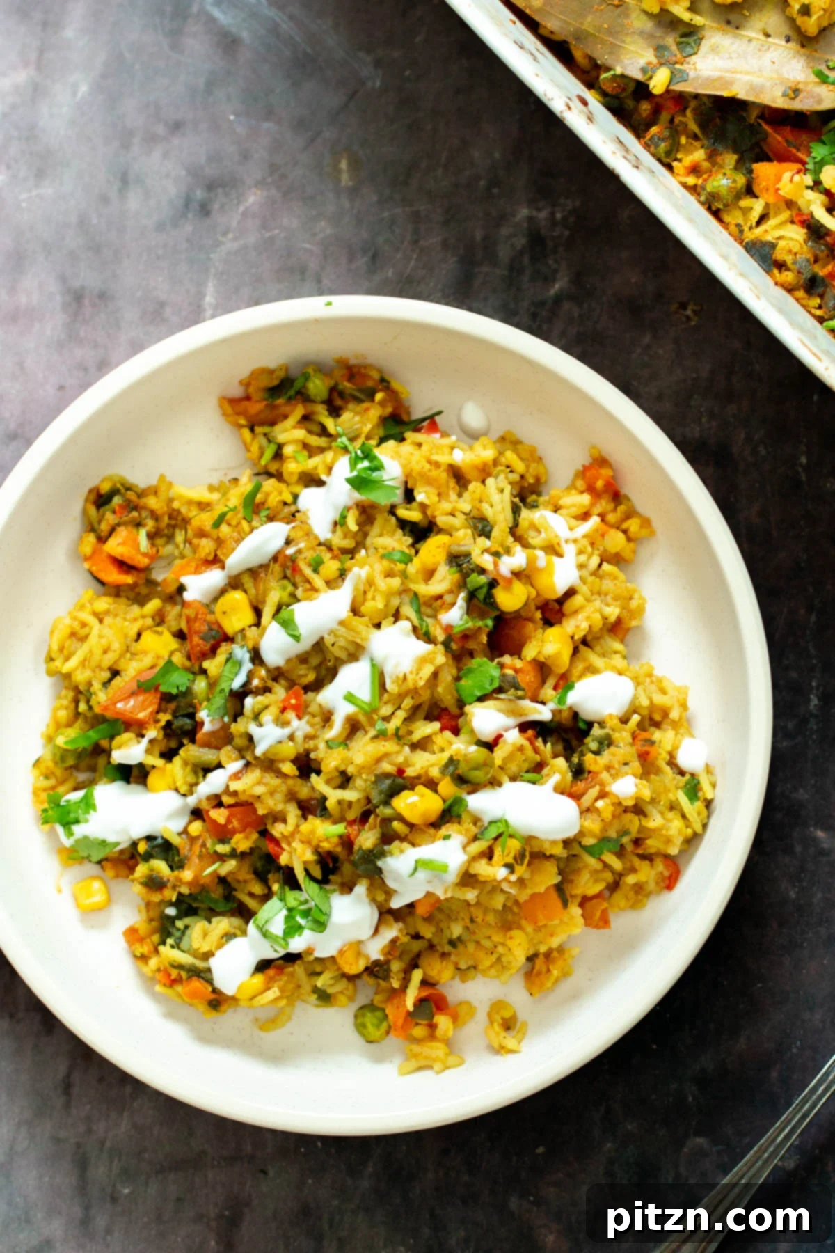 Spiced Kitchari Comfort Bake 4 A beautifully plated serving of vegan baked Kitchari lentil rice casserole, adorned with fresh herbs and a dollop of vegan yogurt, ready to be enjoyed as a wholesome and satisfying meal.