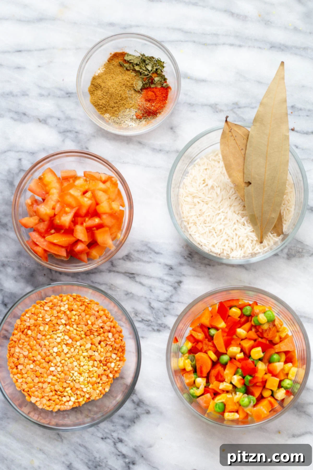 Spiced Kitchari Comfort Bake 7 A collection of fresh ingredients laid out for making Kitchari casserole, including lentils, rice, various colorful vegetables, and an array of aromatic Indian spices, ready for preparation.