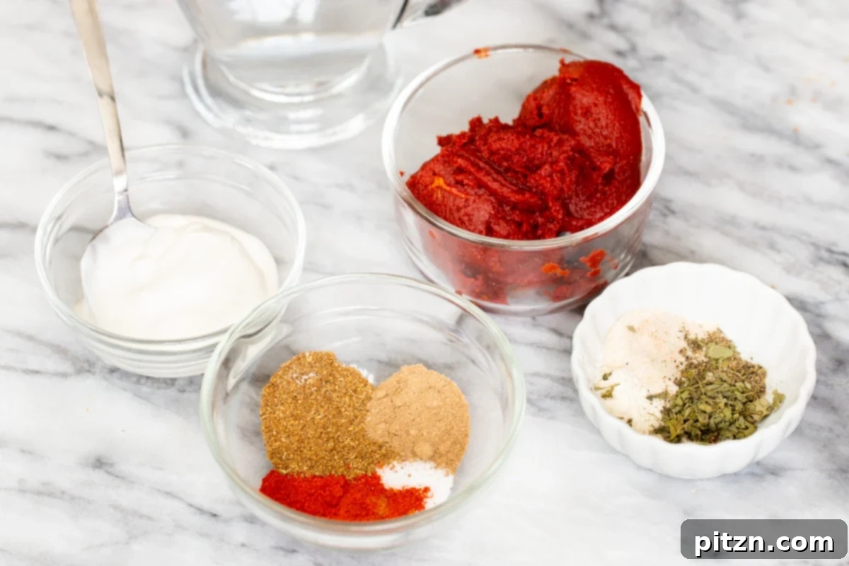 Various dry spices including ground coriander, garam masala, and chili powder, along with fresh vegetables like mushrooms, peppers, and onions, are arranged on a light marble countertop. These ingredients are prepared for crafting the rich vegan birria filling and Tikka Masala sauce.