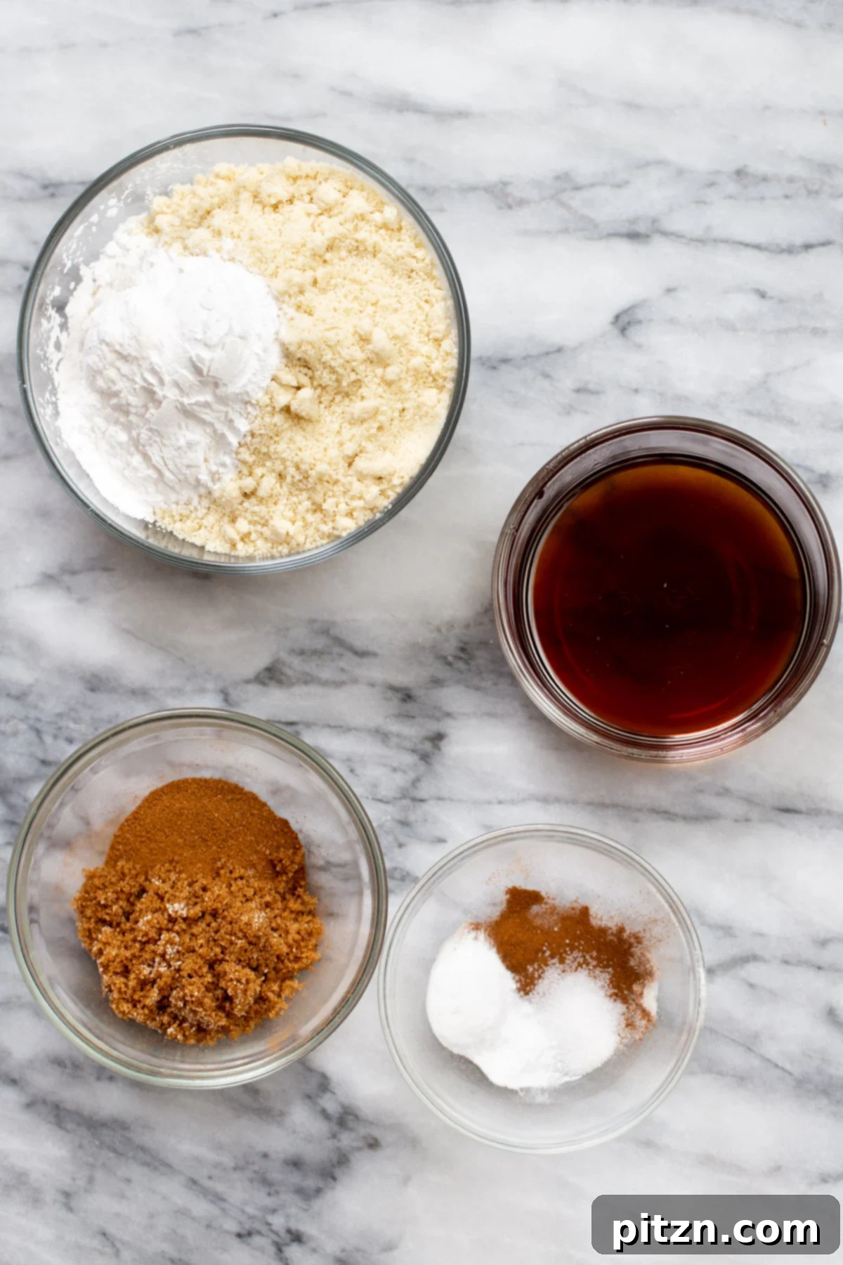 Soft and Chewy Gluten-Free Almond Flour Snickerdoodles 6 A collection of ingredients for making vegan snickerdoodle cookies arranged neatly on a marble countertop, ready for preparation.