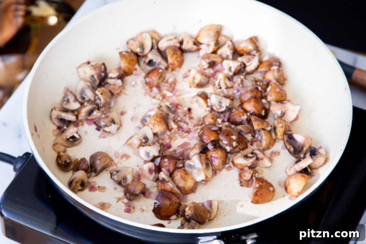 Creamy Vegan One-Pot Pasta: Mushrooms & Sun-Dried Tomatoes 10 Mushrooms, onions, and garlic cooking down in a sautéing pan, getting ready for the next ingredients.
