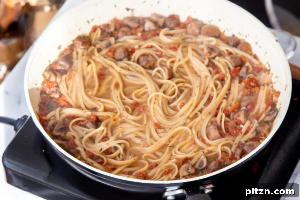 Creamy Vegan One-Pot Pasta: Mushrooms & Sun-Dried Tomatoes 16 Freshly cooked sun-dried tomato mushroom pasta, perfectly al dente, resting in its savory sauce in the saucepan.