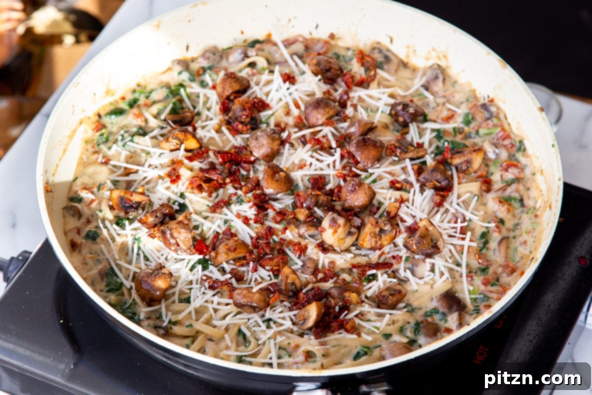 Creamy Vegan One-Pot Pasta: Mushrooms & Sun-Dried Tomatoes 21 Mushroom, spinach, and sun-dried tomato pasta, richly coated in creamy sauce, beautifully plated and ready to be served.