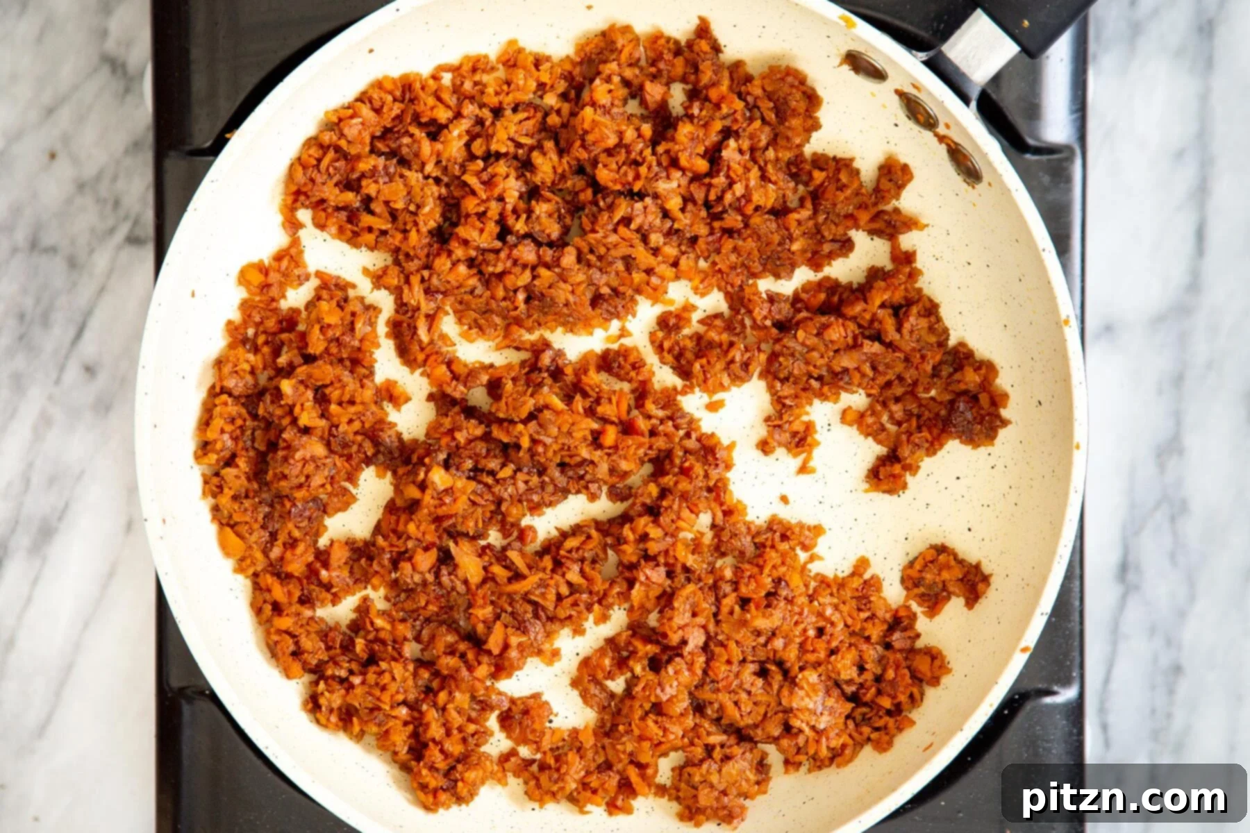 Spiced Vegan Carrot Cake Squares 10 Caramelized shredded carrots in a white frying pan