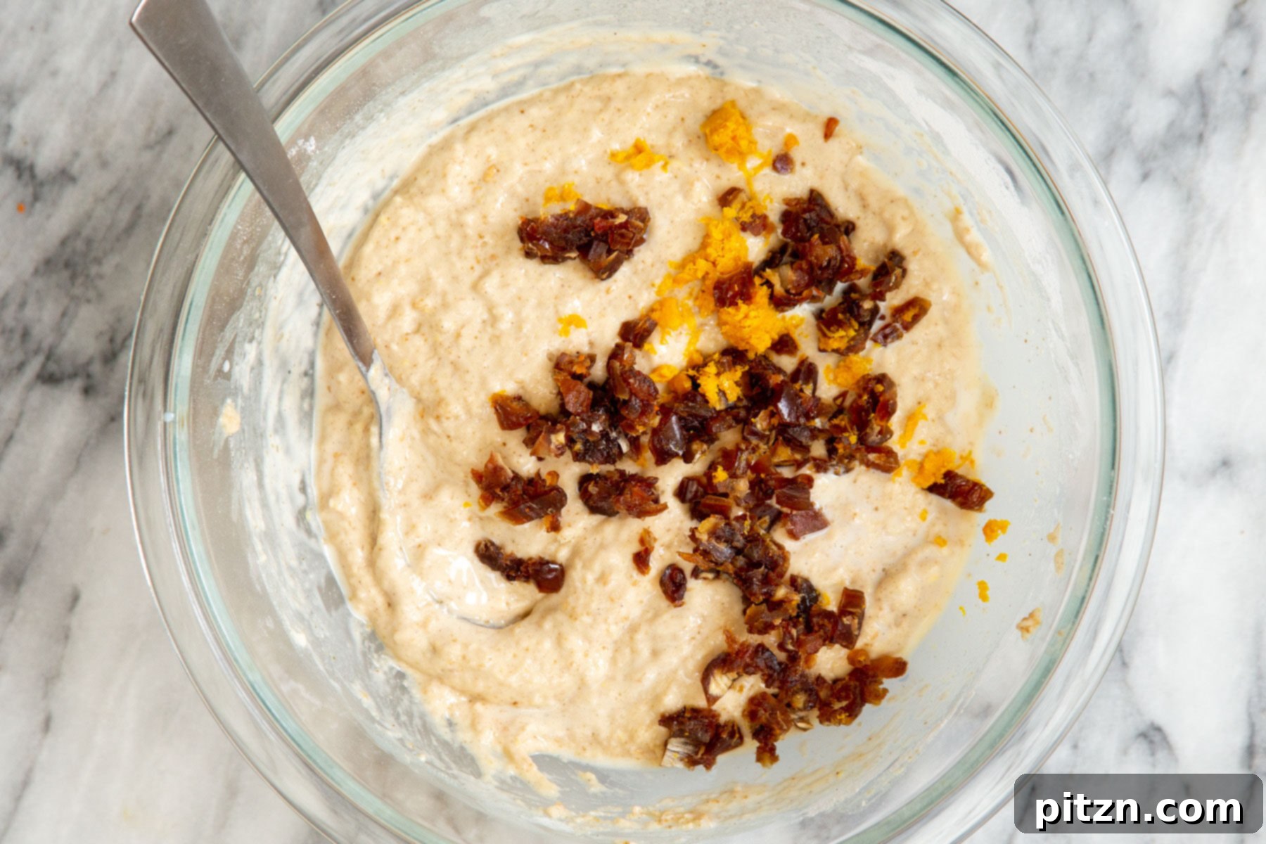 Spiced Vegan Carrot Cake Squares 16 Chopped dates and orange zest being added to carrot cake batter