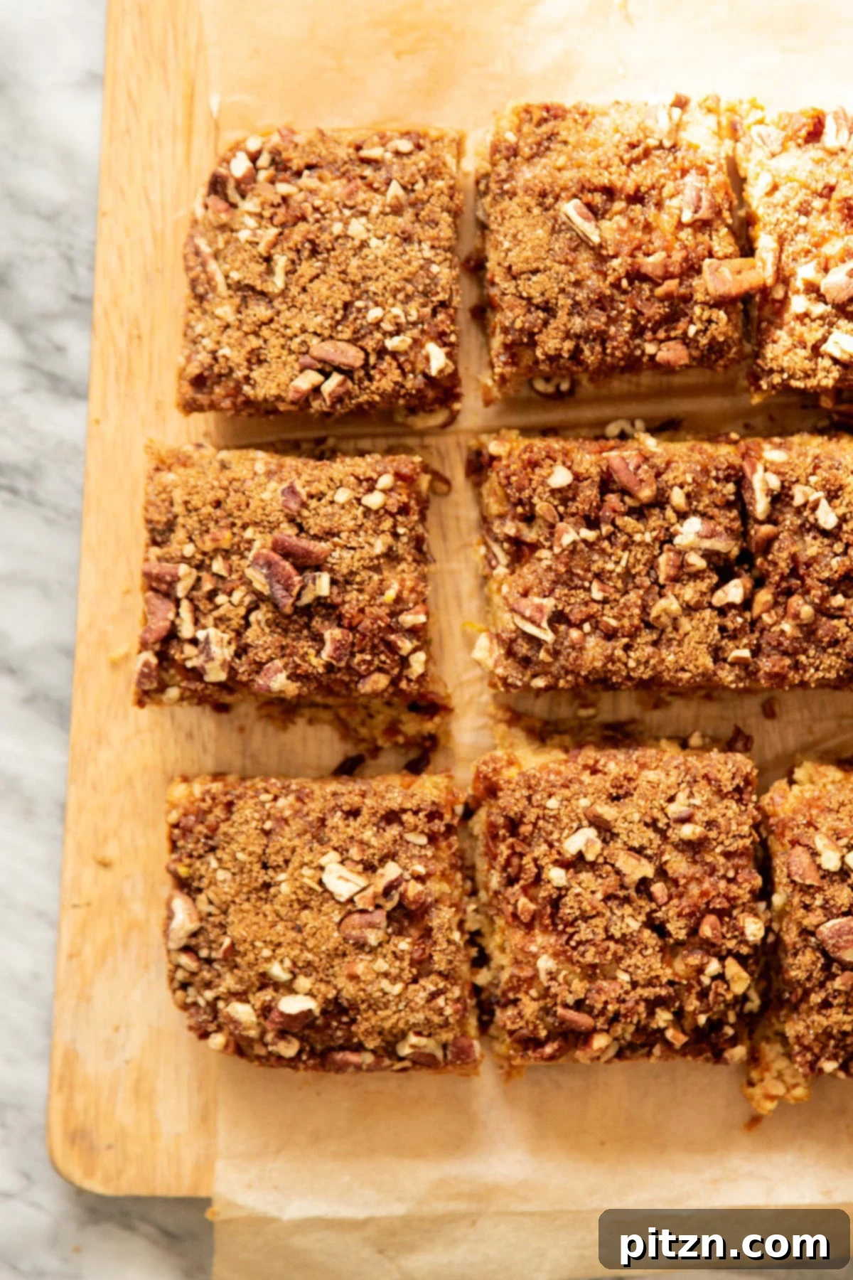 Spiced Vegan Carrot Cake Squares 3 Sliced vegan carrot cake bars on a sheet of parchment paper
