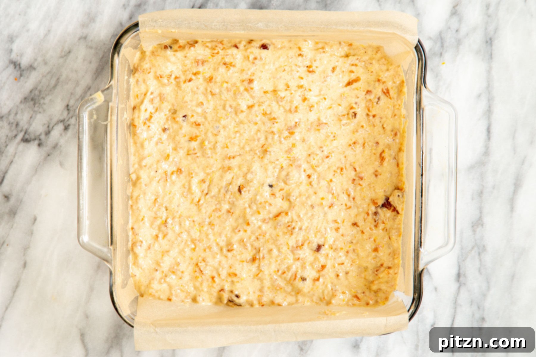 Spiced Vegan Carrot Cake Squares 19 Carrot cake bars batter being spread into a square glass Pyrex dish