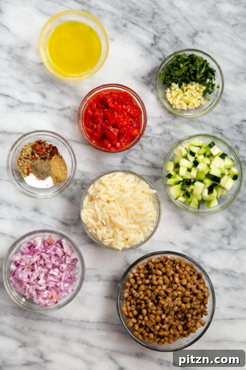 A flat lay image displaying all the fresh ingredients required to make the vibrant vegan lentil farro salad, neatly arranged on a white surface.