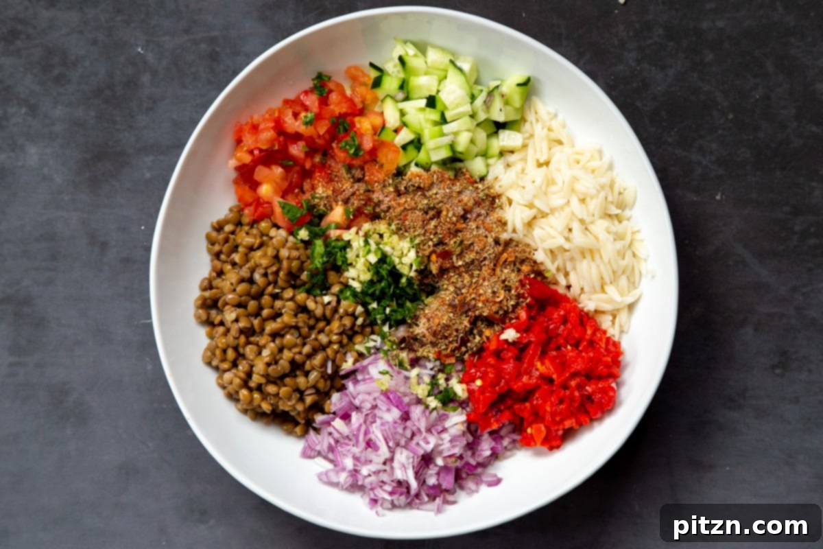 Spices and a rich dressing are being carefully poured and mixed into the vibrant lentil farro salad, enhancing its flavor profile.