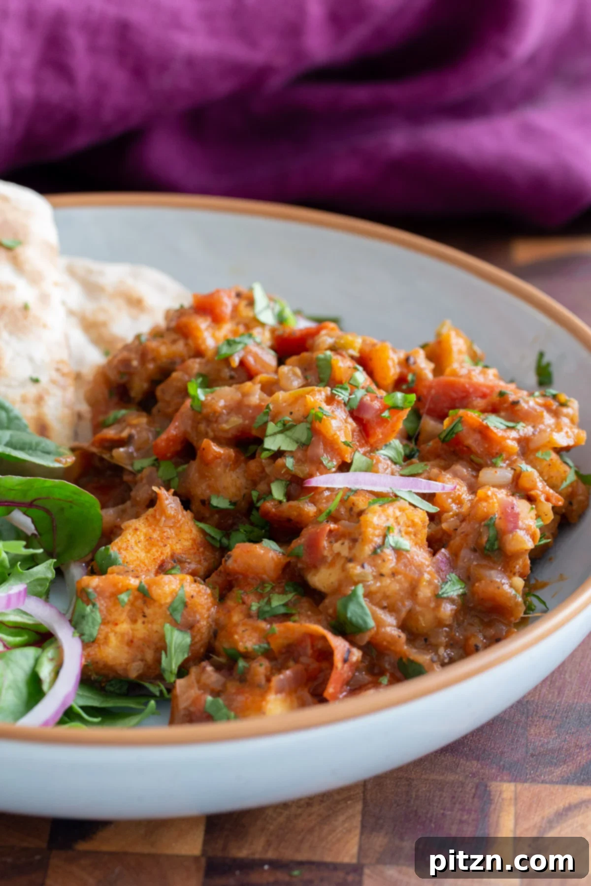 A vibrant serving of Vegan Khada Masala Murg with flatbread and a refreshing side salad, highlighting the rich colors and textures of the dish.