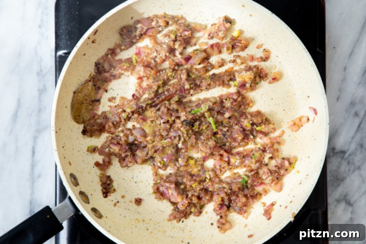 The vibrant tempering mixture, now enriched with ground spices, simmering gently in the sautéing pan.