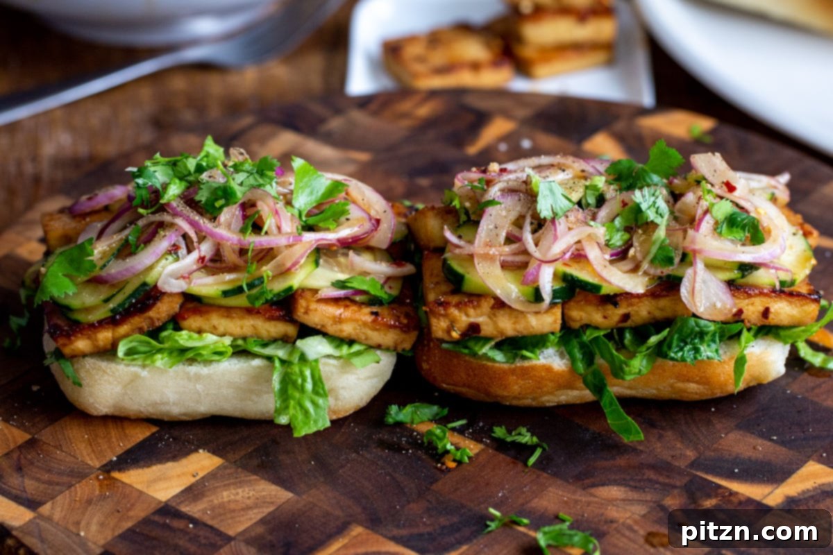 assembled chili garlic tofu sandwiches on a chopping board