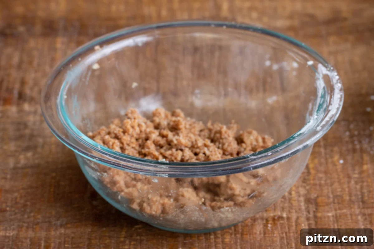Gluten-Free Vegan Blueberry Muffin Cookies 10 Brown sugar streusel mixture, containing almond flour and spices, being prepared in a clear glass bowl for Vegan Blueberry Muffin Cookies.