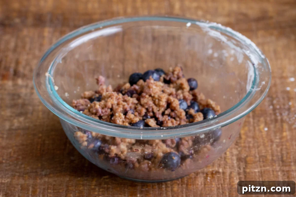 Gluten-Free Vegan Blueberry Muffin Cookies 12 Finished blueberry streusel dough in a glass bowl, showcasing the juicy berries and crumbly texture. Ready to top the Vegan Blueberry Muffin Cookies.