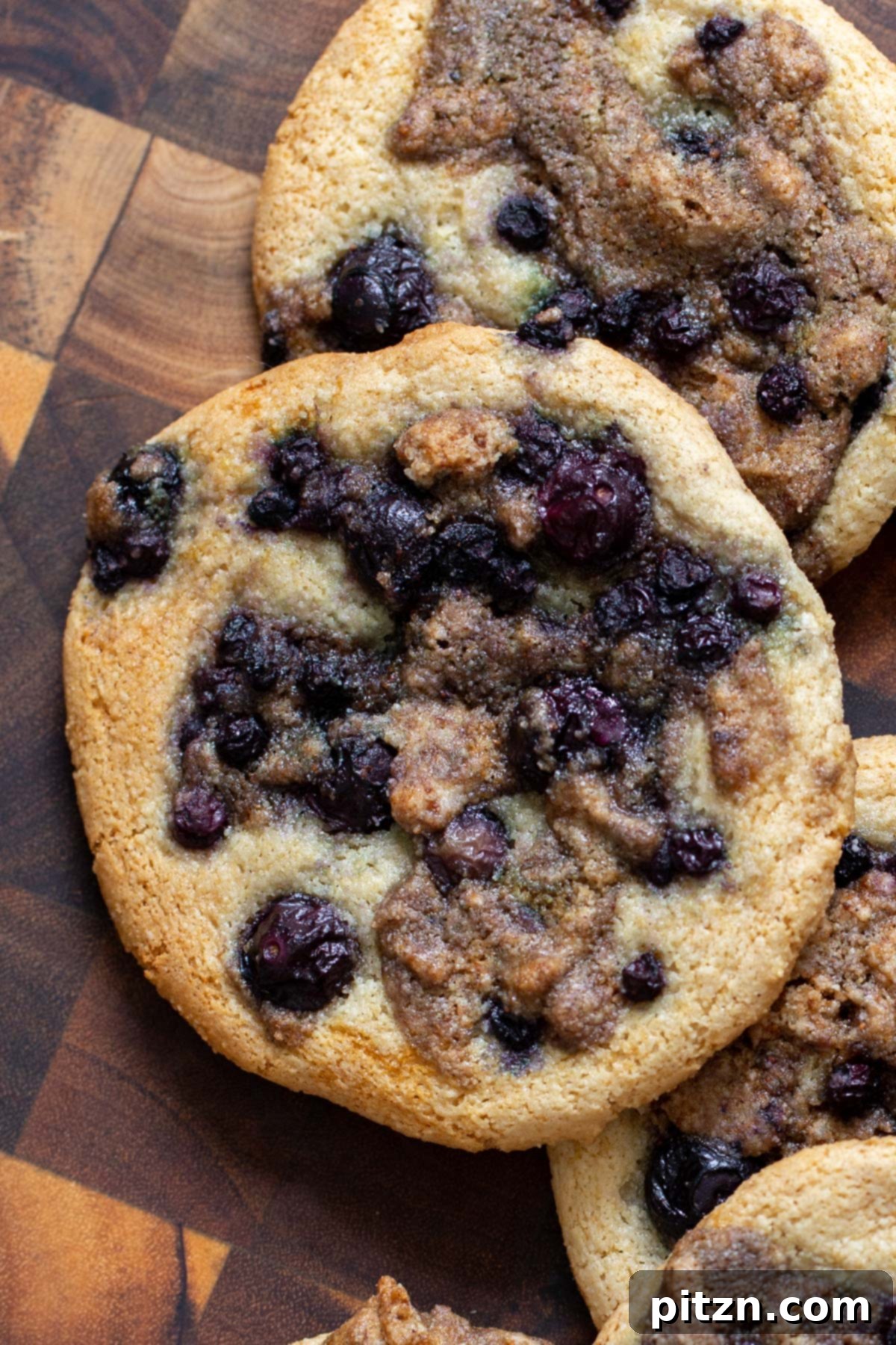 Gluten-Free Vegan Blueberry Muffin Cookies 18 A close-up of a stack of Vegan Blueberry Muffin Cookies on a wooden board, showing the soft interior and generous blueberry streusel topping. Gluten-Free goodness.