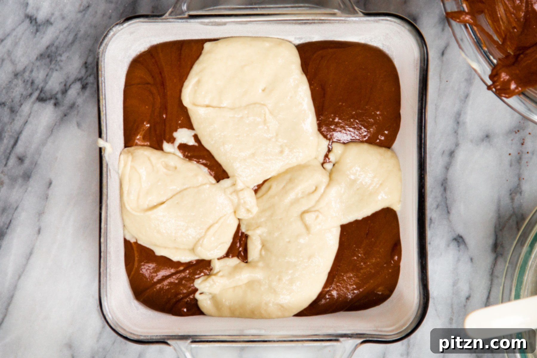 Decadent Mocha Swirl Cake 15 Alternating spoonfuls of light vanilla and dark mocha cake batter are carefully added to a prepared square baking pan.