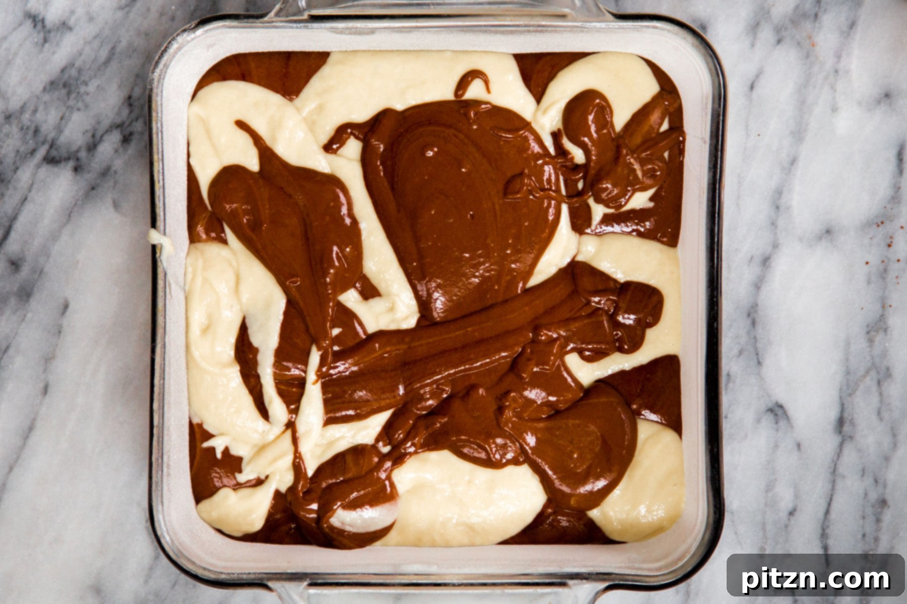 Decadent Mocha Swirl Cake 16 A close-up of swirled vegan vanilla and mocha cake batter in a square pan, ready for baking.