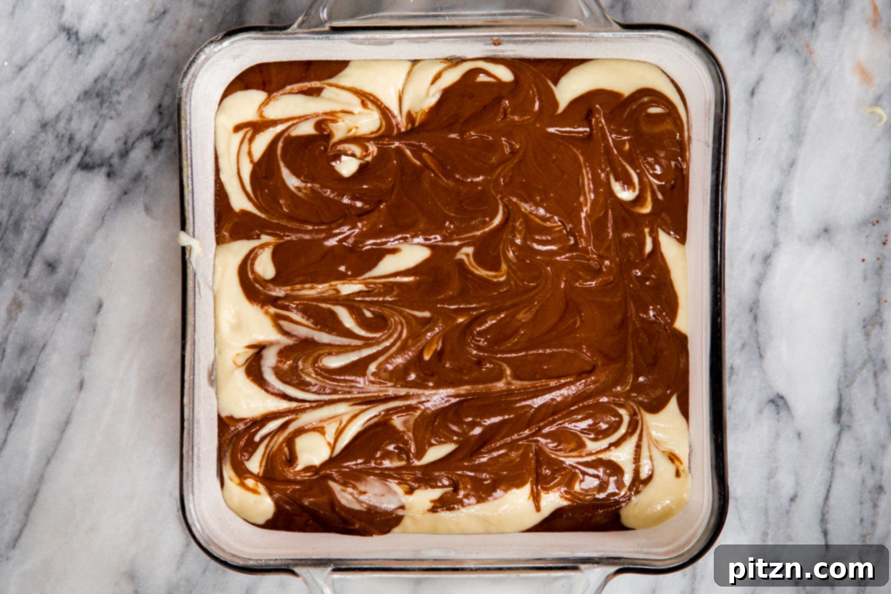Decadent Mocha Swirl Cake 17 A square cake pan showcasing the beautiful swirled patterns of vegan mocha and vanilla batter before baking.